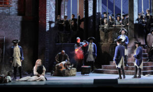 Soldier handcuffing street workers in Manon Lescaut (SF Opera)
